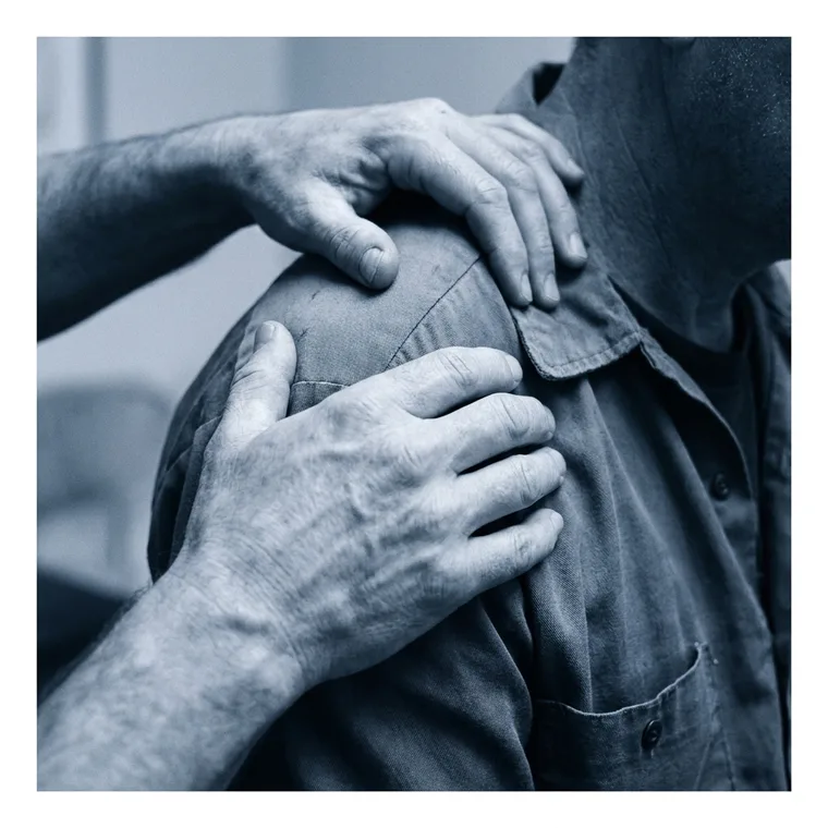 Close detail of a hands-on shoulder assessment